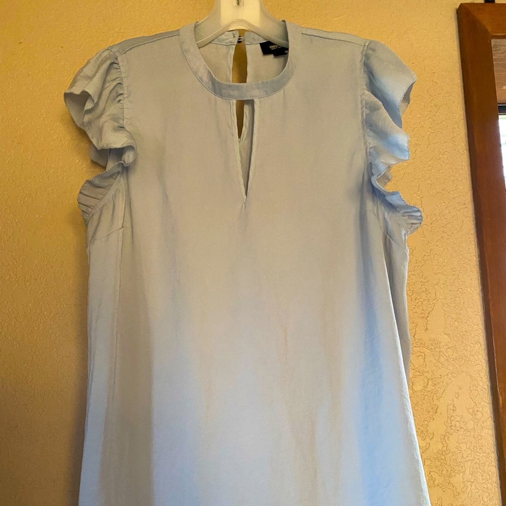 Light blue blouse with ruffle sleeve detail.